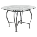 Mesa de comedor redonda de cristal con estructura metálica curvada